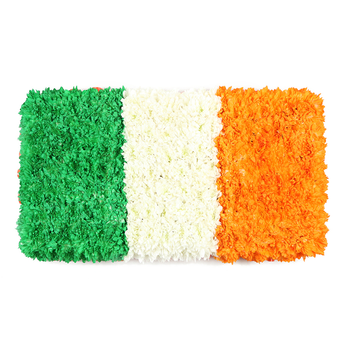 An elegant, rectangular homage to the Irish flag, created entirely from thousands of tiny petals, stands proudly against a clean white backdrop. From left to right, the three equal vertical stripes-emerald green, pristine white, and bright orange-form a lush, three-dimensional surface that feels almost living to the touch. The green bar seems carpeted with densely packed green blooms, probably chrysanthemums or carnations, whose tiny faces catch the light and offer a velvet-kind texture. The central white stripe is a compact bouquet within a veil of petals, radiating calm and clarity. The orange stripe on the right mirrors the texture of the other two, a sunlit glow that completes the trio. The arrangement is both a piece of art and a symbol, conveying national pride, unity, and a hope for peaceful coexistence. The white background makes the colours sing, while the handcrafted spacing and alignment reflect a craftsman's care and discipline. Here in Somers Town, near bustling streets and markets, such a floral flag is a tasteful complement to cultural features, St Patrick's Day events, or commemorations, and can be arranged for same-day delivery across the area by Flower Delivery Somers Town. This display embodies a moment of shared heritage, offered with the warmth and reliability that local customers expect. Each petal catches light differently, giving the flag a gentle shimmer as if it were fluttering in a soft morning breeze. The overall effect is both dignified and approachable, inviting families, neighbours, and visitors to pause, reflect, and smile at a carefully crafted reminder of community and history. Whether marking a festival, a charity moment, or a day of national sentiment, this hand-tied floral flag speaks with quiet authority, a testament to the craft and care that our Somers Town team brings to every arrangement.